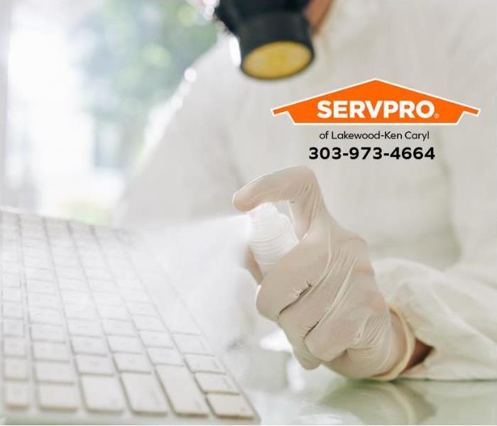 A SERVPRO technician sanitizes computer equipment in a home office.