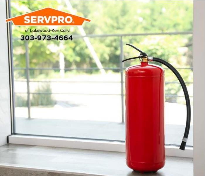 A portable fire extinguisher sits on a windowsill in a home.